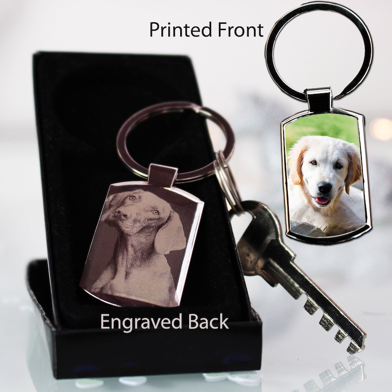 May include: A silver keyring with a black box. The front of the keyring has a colour photo of a golden retriever puppy. The back of the keyring has a black and white photo of a dog. The text "Printed Front" is above the keyring and the text "Engraved Back" is below the keyring.