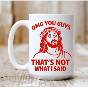 Pu&ograve; includere: Tazza in ceramica bianca con grafica rossa di un uomo con barba e corona di spine. La tazza presenta la scritta rossa "OMG YOU GUYS THAT'S NOT WHAT I SAID".