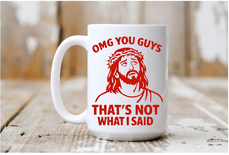 Pu&ograve; includere: Tazza in ceramica bianca con grafica rossa di un uomo con barba e corona di spine. La tazza presenta la scritta rossa "OMG YOU GUYS THAT'S NOT WHAT I SAID".