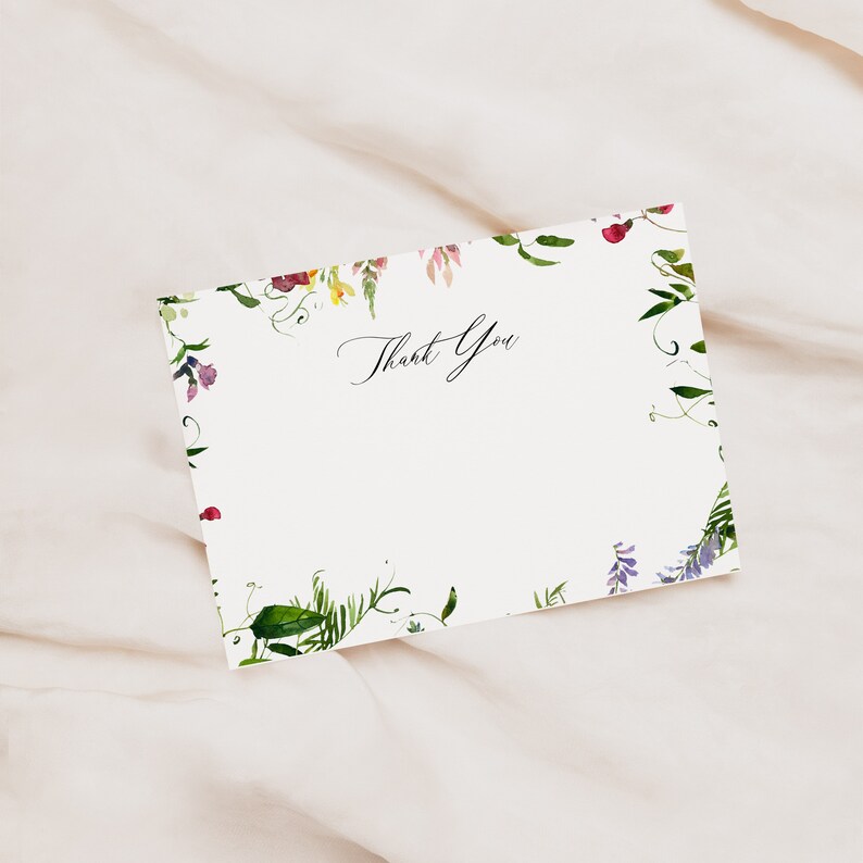May include: A white thank you card with a floral border. The border is made up of watercolour illustrations of green leaves, purple, pink, and yellow flowers.