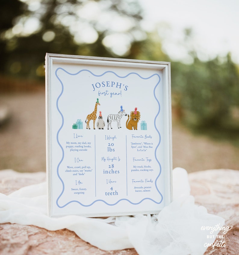 May include: A framed print with a blue border and the text "Joseph's first year!" includes illustrated animals wearing party hats. The print lists the child's weight as 20 lbs and height as 28 inches.