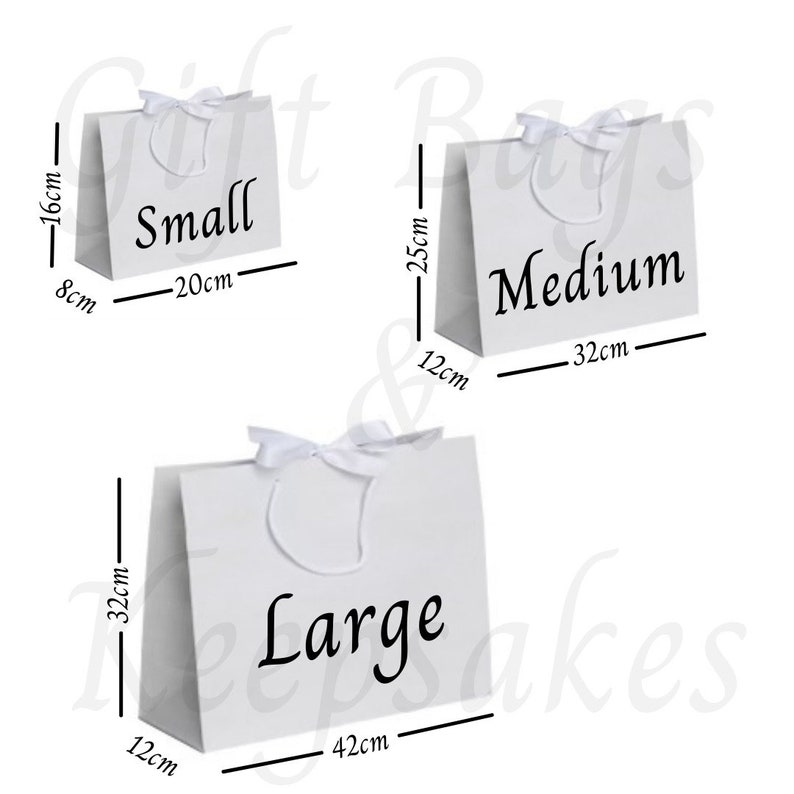 Pode incluir: Tr&ecirc;s sacolas de presente brancas rotuladas como "Small", "Medium" e "Large". A sacola pequena tem 8cm x 20cm x 16cm, a m&eacute;dia tem 12cm x 32cm x 25cm e a grande tem 12cm x 42cm x 32cm. Cada sacola tem uma al&ccedil;a de fita branca.