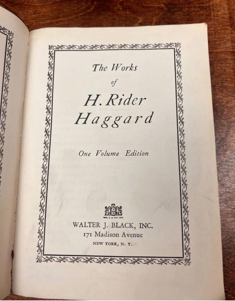 以下が含まれることがあります： 「The Works of H. Rider Haggard」のタイトルページが表示された開いた本。テキストは黒色で、オフホワイトのページに書かれており、装飾的なボーダーで囲まれています。ニューヨークの住所を含む出版社の情報も表示されています。