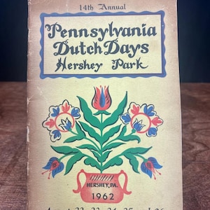 Puede incluir: Programa del evento Pennsylvania Dutch Days en Hershey Park de 1962. La portada presenta un diseño floral en rojo, azul y verde, con el título del evento en una fuente decorativa. El programa está desgastado.