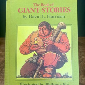 Puede incluir: Un libro antiguo de tapa dura titulado "The Book of Giant Stories" de David L. Harrison, ilustrado por Philippe Fix. La portada presenta una colorida ilustración de un gigante sosteniendo una pequeña figura. El libro tiene una cubierta verde con texto rojo y negro.