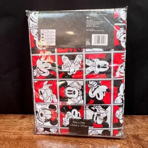 以下が含まれることがあります： ミッキーマウスの様々なポーズが繰り返されるパターンが特徴の、パッケージされた長方形のベッドシーツセット。デザインは黒、白、赤で、パッケージの寸法は132cm x 177cmです。