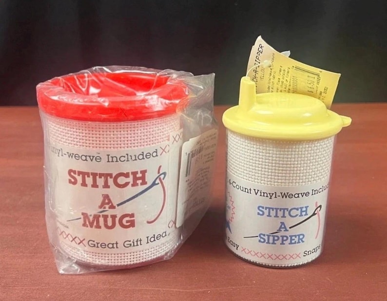 K&ouml;nnte beinhalten: Zwei Bastelsets zur Gestaltung von Trinkgef&auml;&szlig;en. Das linke Set ist ein Stitch A Mug mit rotem Deckel in Klarsichtfolie. Das rechte Set ist ein Stitch A Sipper mit gelbem Deckel und Trinkhalm&ouml;ffnung, mit wei&szlig;em Vinyl-Gewebe f&uuml;r Handarbeiten.