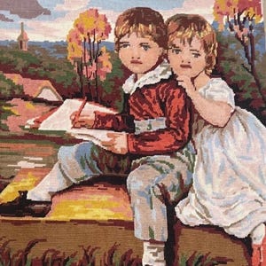 May include: A needlepoint tapestry depicting two children sitting outdoors. One child wears a red jacket and light-colored trousers while writing in a book. The other child wears a white dress and leans against the first child. The background features trees, a building, and a cloudy sky.