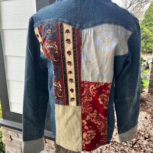 May include: A white ceramic mug with a black handle and the text "But First, Coffee" in a black, handwritten-style font. The mug is on a white surface.