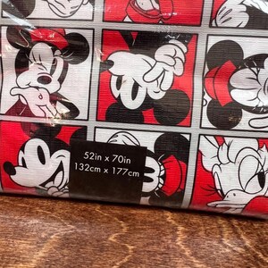 以下が含まれることがあります： ミッキーマウスとミニーマウスの白、黒、赤の正方形の繰り返し模様が特徴の、丸められた布地。サイズは132cm x 177cmです。布地は木製の表面にあります。