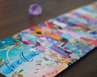 May include: A rectangular card featuring a vibrant collage of colorful illustrations, including a clock face, a sunflower, and white roses. The text 'Time Out' is written in black script across the front, with the Roman numeral XXVIII visible.