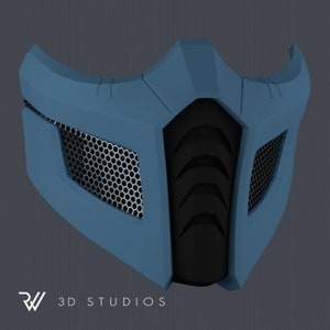 May include: A blue and black face mask with a geometric design. The mask features a mesh screen on each side and a central black section with a ridged pattern. The text "3D STUDIOS" is at the bottom.