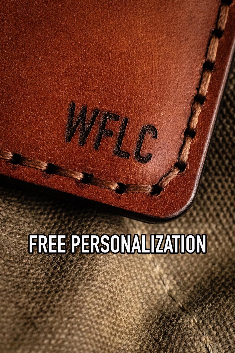 May include: Close-up of a brown leather wallet with the text "WFLC" embossed on the front. The wallet is lying on a brown canvas fabric. The text "FREE PERSONALIZATION" is visible below the wallet.