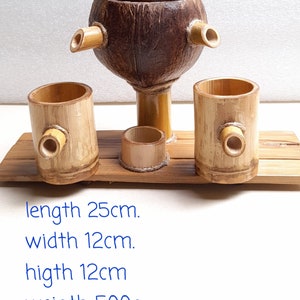 May include: A wooden serving set with a coconut shell bowl and three bamboo cups. The set is 25 inches long, 12 inches wide, and 12 inches high. It weighs 500 grams.