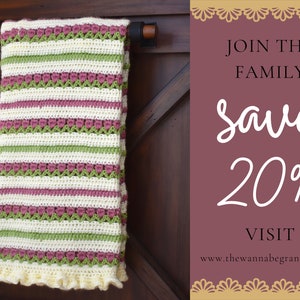 May include: A crocheted blanket with pink, green, and white stripes hangs on a wooden door. The blanket has a crocheted ruffle around the bottom edge. The text on the sign reads "Join the Family Save 20% Visit www.thewannabegrandma.com"