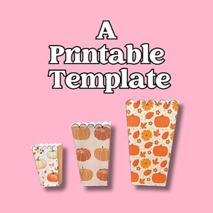 May include: Three printable popcorn boxes with a scalloped top edge. The boxes feature a fall theme with pumpkins, leaves, and flowers in orange and cream colors. The text "A Printable Template" is displayed above the boxes.