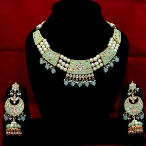 May include: A green and gold necklace and earrings set with pearl accents. The necklace has three rows of pearls and green enamel pendants with floral designs. The earrings are dangle style with a similar green enamel design.