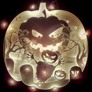 Può includere: Un'opera d'arte in carta a strati con una scena di Halloween. Il design include una grande zucca, alberi, uno spaventapasseri e lapidi. L'opera d'arte è illuminata da una calda luce, creando un'atmosfera spettrale.