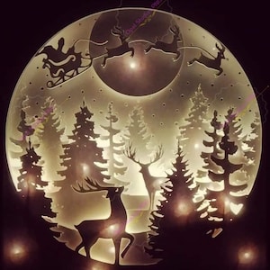 May include: A white, circular, wooden sign with a silhouette of Santa Claus and reindeer flying over a moon and forest. The sign is illuminated with warm white lights.