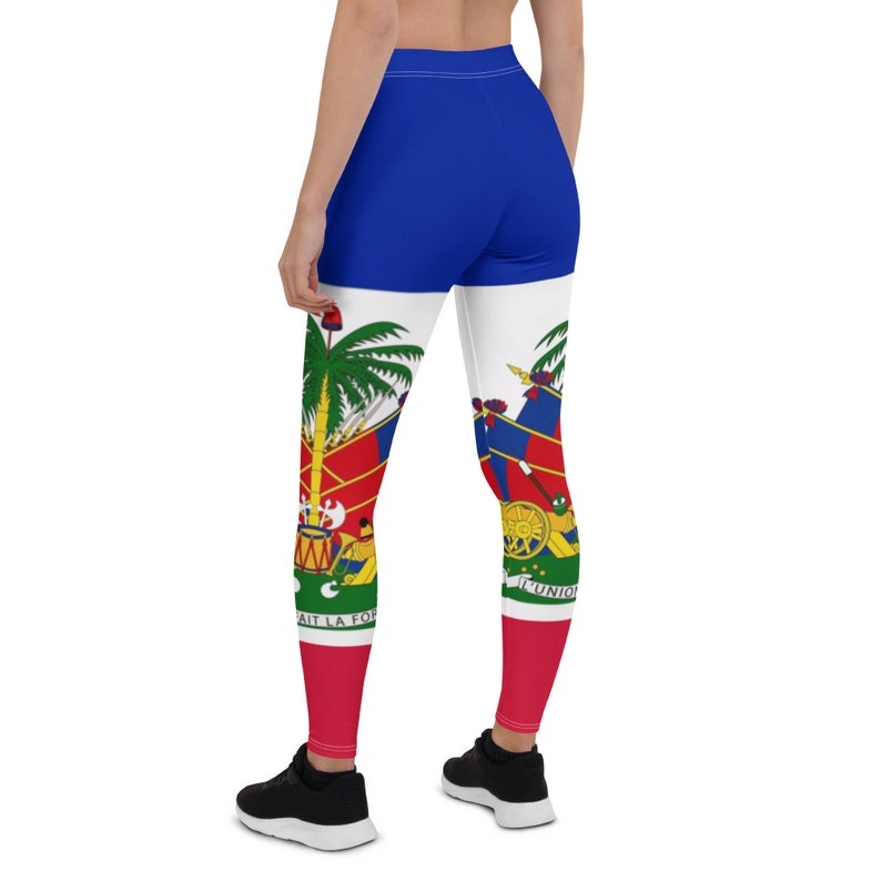 Może przedstawiać: Legginsy w kolorze niebieskim, czerwonym i białym z nadrukowaną flagą Haiti. Legginsy są noszone przez osobę stojącą tyłem do kamery.