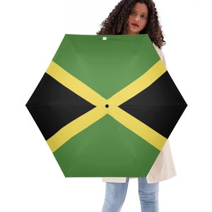 Puede incluir: Un paraguas verde, amarillo y negro con el diseño de la bandera de Jamaica.