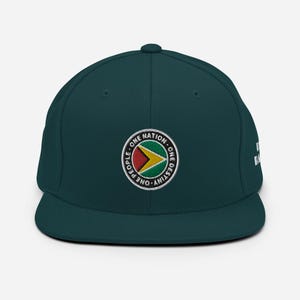 Puede incluir: Una gorra de béisbol verde oscuro con un parche bordado que presenta la bandera de Guyana y el texto "One Nation - One People - One Destiny".