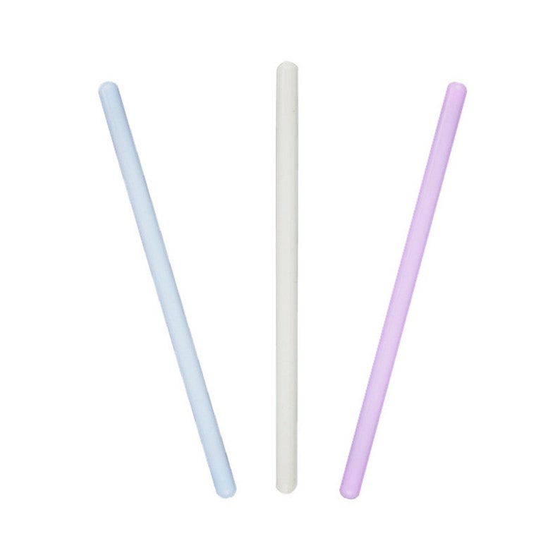 May include: Three glass stirring sticks in different colors: light blue, white, and light purple.