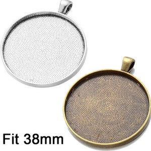 Op de afbeelding: Twee hanger-schalen, een zilveren en een bronzen, met een getextureerd oppervlak. Beide schalen zijn 38 mm in diameter en hebben een lus aan de bovenkant om een ​​ketting aan te bevestigen.