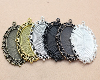 Puede incluir: Seis bandejas ovaladas de metal para colgantes con bordes ornamentados. Las bandejas están en varios acabados, incluyendo plata, oro y negro.