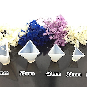 May include: Five clear silicone pyramid moulds of different sizes. The moulds are arranged from largest to smallest, with the largest mould measuring 60mm, the next largest 50mm, then 40mm, 30mm, and finally 20mm.