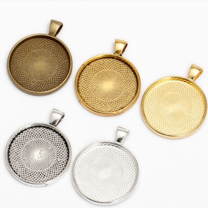 Può includere: Cinque vassoi rotondi in metallo per ciondoli con un motivo decorativo. I vassoi sono di diversi colori: oro, argento e bronzo. Ogni vassoio ha un anello nella parte superiore per appenderlo.