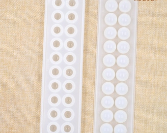 May include: Two white silicone molds for making round resin or polymer clay beads. Each mold has 12 round cavities. The mold on the left has a rectangular shape and the mold on the right has a long rectangular shape. The molds are labeled "MD2027".