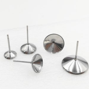 May include: Five silver earring posts with a round, flat top. The posts are designed to hold a cabochon.