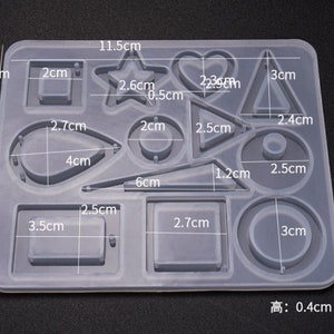 May include: A clear silicone mold with 12 different shapes for crafting. The shapes include a star, heart, circle, square, teardrop, and more. The mold measures 11.5 inches by 9.5 inches and is 0.4 inches high.