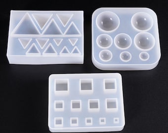 May include: Three silicone molds for resin casting. The first mold has a pattern of triangles. The second mold has six round cavities. The third mold has nine square cavities.