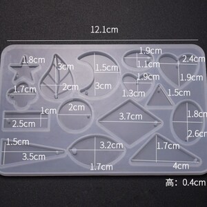 May include: A clear silicone mold with 14 different shapes for resin casting. The shapes include a star, leaf, crescent moon, circle, oval, heart, triangle, rectangle, and more. The mold measures 12.1 cm by 8 cm and is 0.4 cm high.