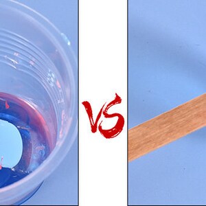 May include: A blue and red resin mixture is being stirred with a blue plastic stick in a clear plastic cup.  The same stick is shown resting on top of a blue plastic lid.
