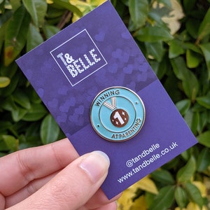 Grön emaljnål med vinnande motiv i föräldraskapet - Inkluderande föräldrapresent