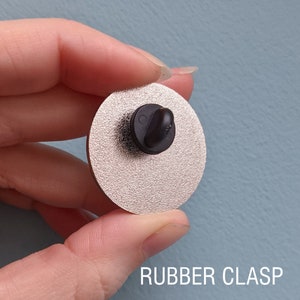 The back of an enamel pin with a rubber clasp.