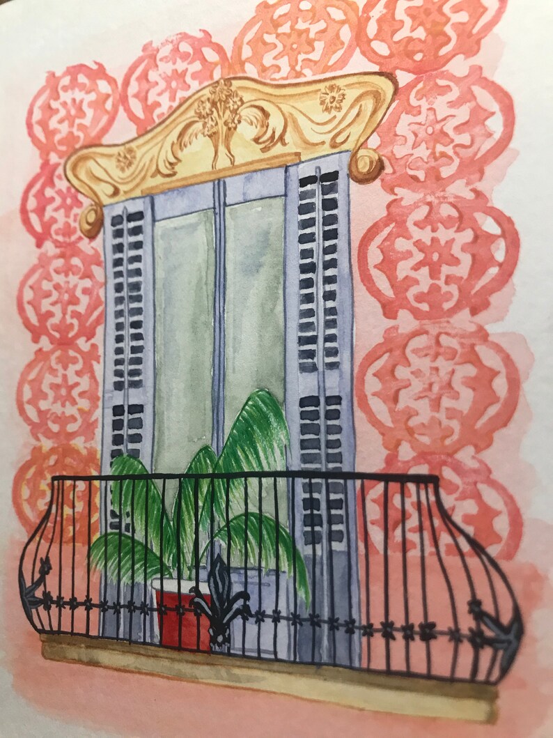 May include: A watercolor painting of a window with a balcony. The window is decorated with ornate gold trim and has blue shutters. A potted plant sits on the balcony, which has a black wrought iron railing.
