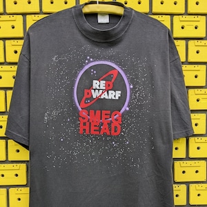 May include: Black t-shirt with a white and purple graphic of a red planet with the text "Red Dwarf" and "Smeg Head" on it.
