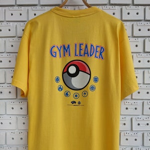 Camiseta vintage de líder de gimnasio de Pokémon del año 2000, Ash, Pikachu, Brock, Misty, juego de cartas coleccionables, liga Wizards Of The Coast TCG, camiseta de merchandising, talla L