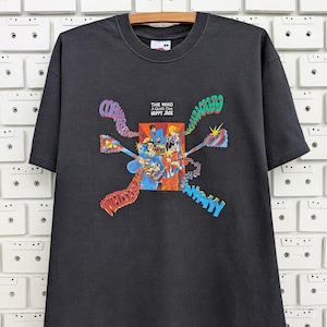 Puede incluir: Camiseta negra con un gráfico colorido de la portada del álbum "A Quick One" de The Who. El título del álbum "Happy Jack" está impreso en texto blanco.
