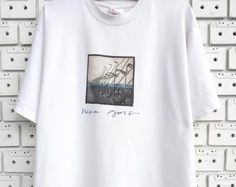Camiseta de golf Nike vintage de los años 2000 con estampado gráfico de carrito de empuje y tracción, talla M/L