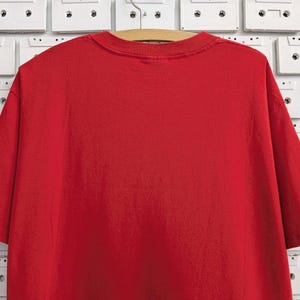 May include: A plain red t-shirt with short sleeves.