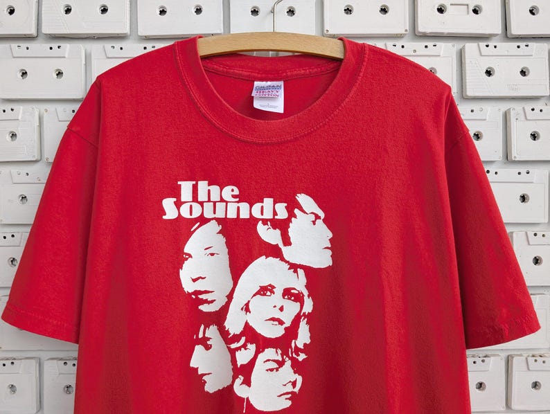 May include: Red t-shirt with a white graphic of the band "The Sounds" and four band members' faces.