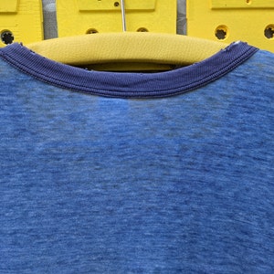 Puede incluir: Una camiseta azul con cuello redondo azul marino. La camiseta est&aacute; hecha de un material suave y c&oacute;modo.