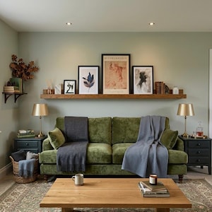 large oak picture ledge. in a cozy living room with framed prints on shelf, luxury green velvet sofa large rug and coffee table.