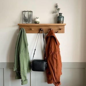 shaker style room and shelf, coats and bag hanging on the shelf.