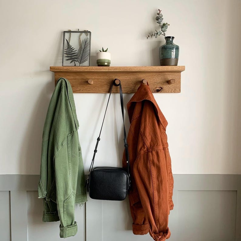 shaker style room and shelf, coats and bag hanging on the shelf.